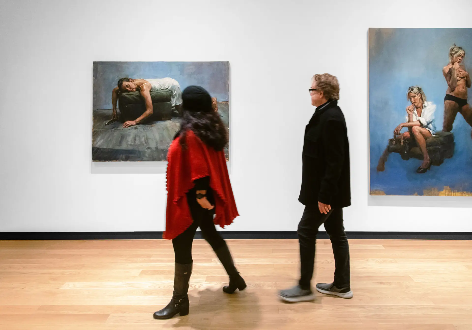 A man and woman admiring paintings from the Jorg Dubin Exhibition