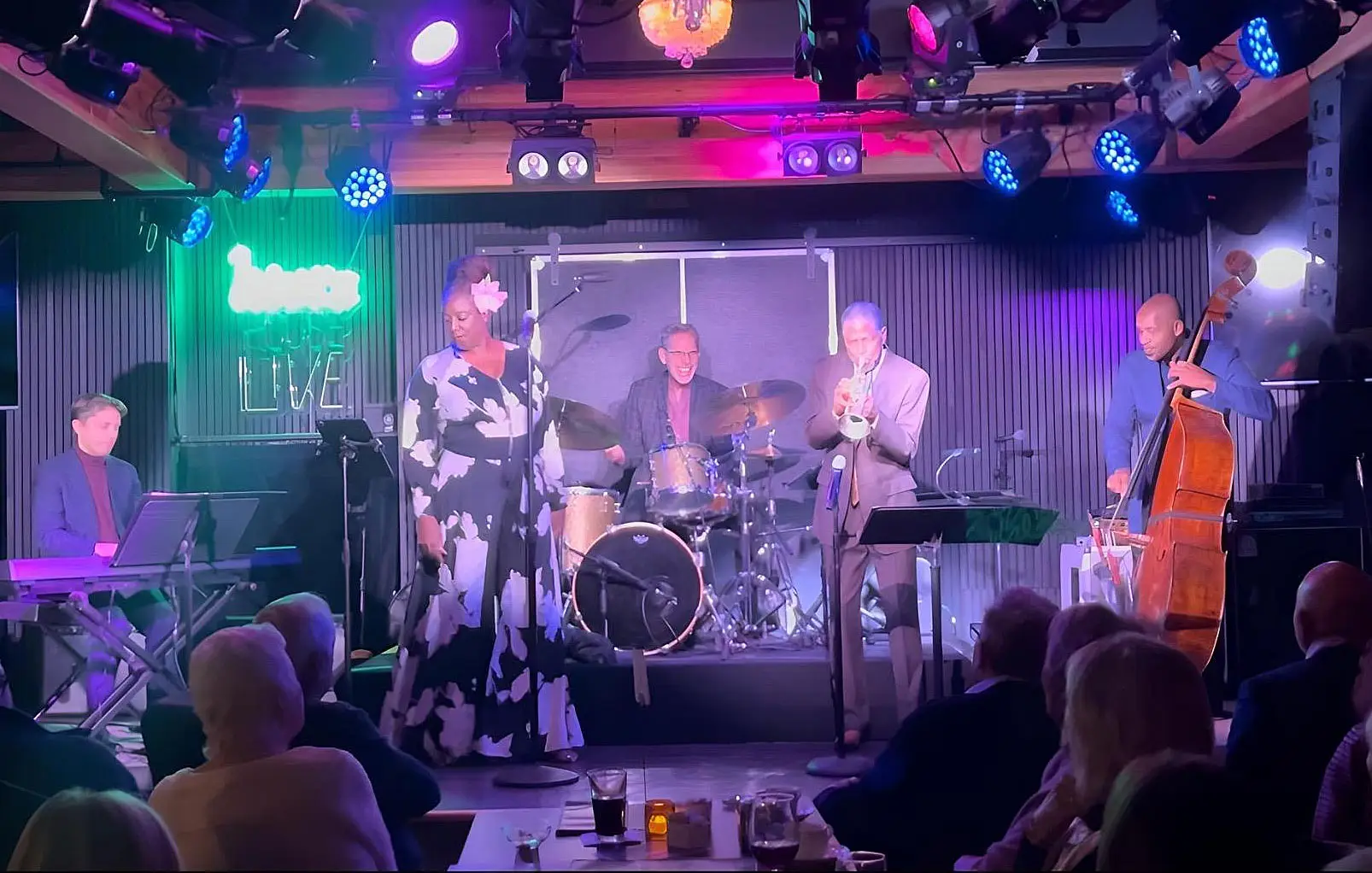 A female singer and a band performing on stage